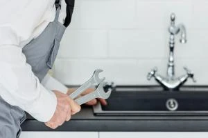 Professionnel NEF intervenant sur une fuite lors d’un dépannage plomberie